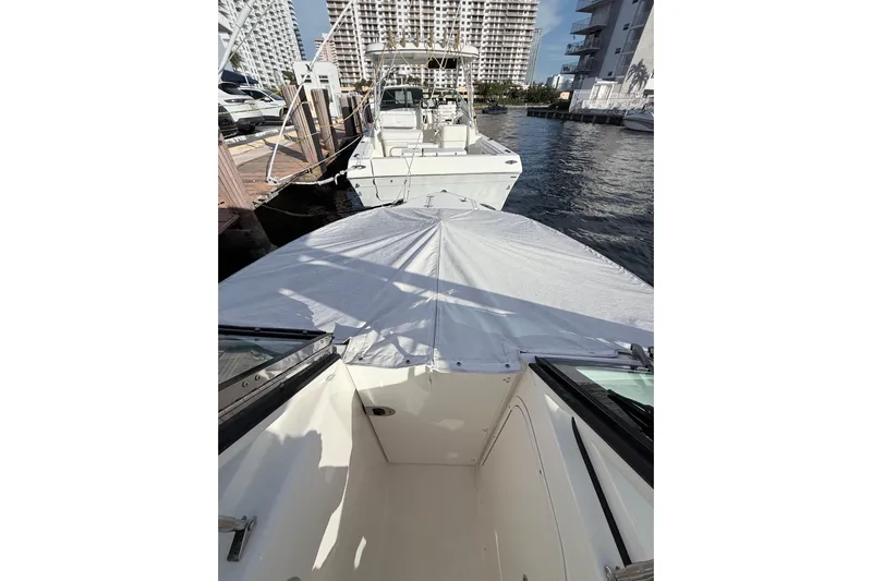  Yacht Photos Pics 2022 Pursuit DC 266 Dual Console boat docked at marina, covered bow, cityscape background.