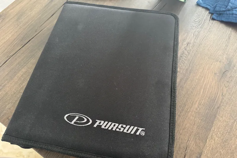  Yacht Photos Pics Black Pursuit folder on wooden table, related to 2022 DC 266 Dual Console.