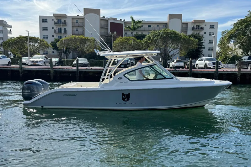  Yacht Photos Pics 2022 Pursuit DC 266 Dual Console boat on water near urban dockside.