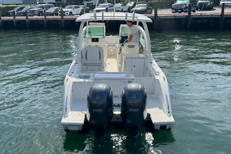 Yacht Photos Pics 2022 Pursuit DC 266 Dual Console boat on water, rear view with twin engines.