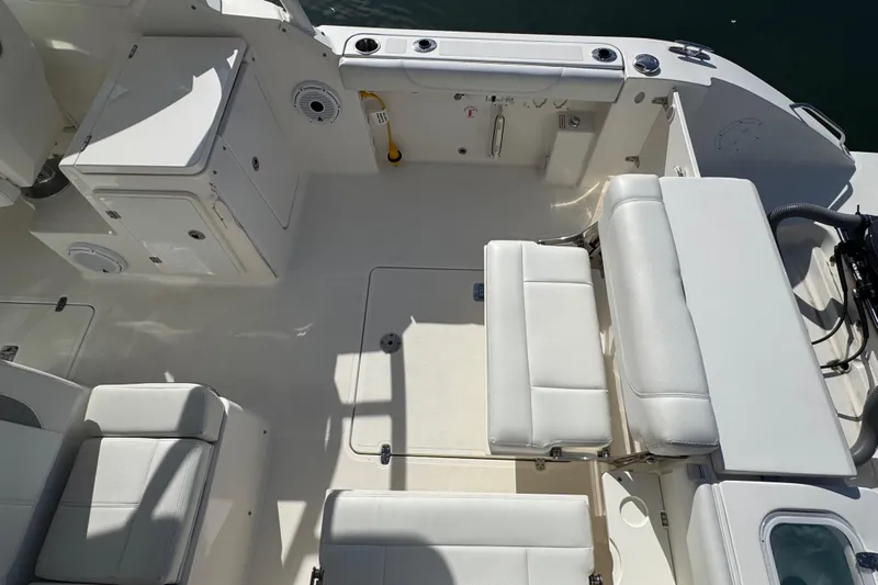  Yacht Photos Pics 2022 Pursuit DC 266 Dual Console boat interior with white seating and storage compartments.