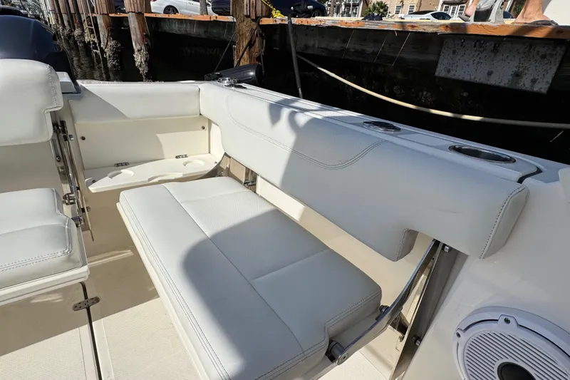  Yacht Photos Pics 2022 Pursuit DC 266 Dual Console boat interior with white seating and cup holders.