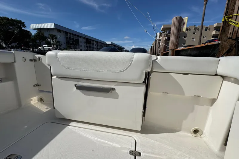  Yacht Photos Pics 2022 Pursuit DC 266 Dual Console boat interior with seating and storage, docked under clear skies.