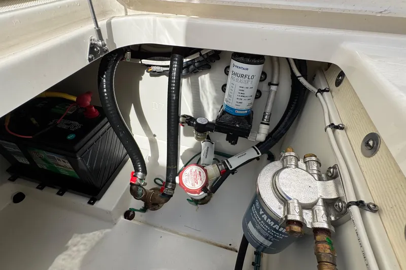  Yacht Photos Pics 2022 Pursuit DC 266 Dual Console boat compartment with battery and pump system.