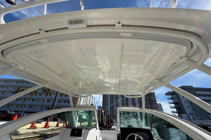  Yacht Photos Pics 2022 Pursuit DC 266 Dual Console boat interior with hardtop, docked near urban buildings.
