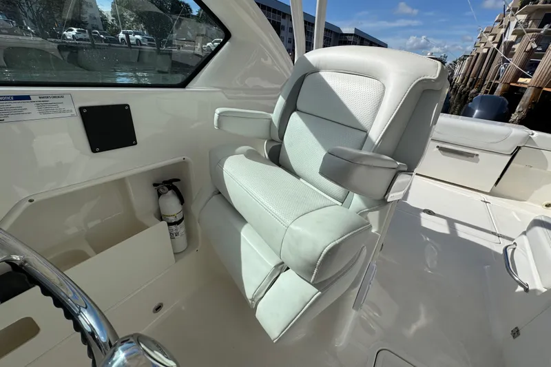  Yacht Photos Pics 2022 Pursuit DC 266 Dual Console boat interior with plush seating and steering wheel.