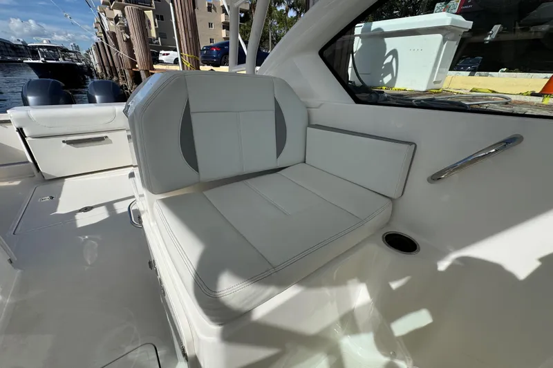  Yacht Photos Pics 2022 Pursuit DC 266 Dual Console boat interior with white seating and docked view.