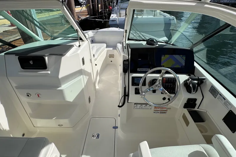  Yacht Photos Pics 2022 Pursuit DC 266 Dual Console boat interior with steering wheel and navigation system.