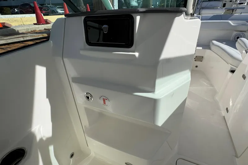  Yacht Photos Pics 2022 Pursuit DC 266 Dual Console interior with storage compartment and seating area.