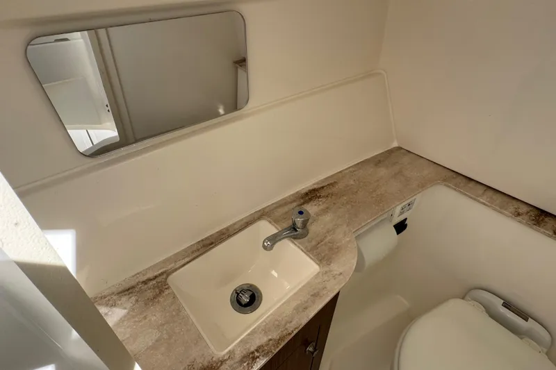  Yacht Photos Pics 2022 Pursuit DC 266 Dual Console boat bathroom with sink and mirror.