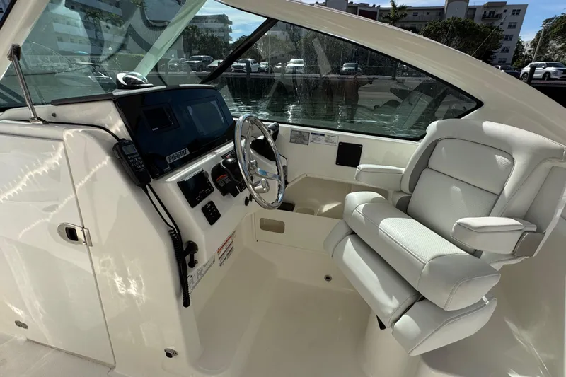  Yacht Photos Pics 2022 Pursuit DC 266 Dual Console boat interior with steering wheel and captain's chair.