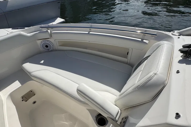  Yacht Photos Pics 2022 Pursuit DC 266 Dual Console boat with white seating and speaker, docked by water.
