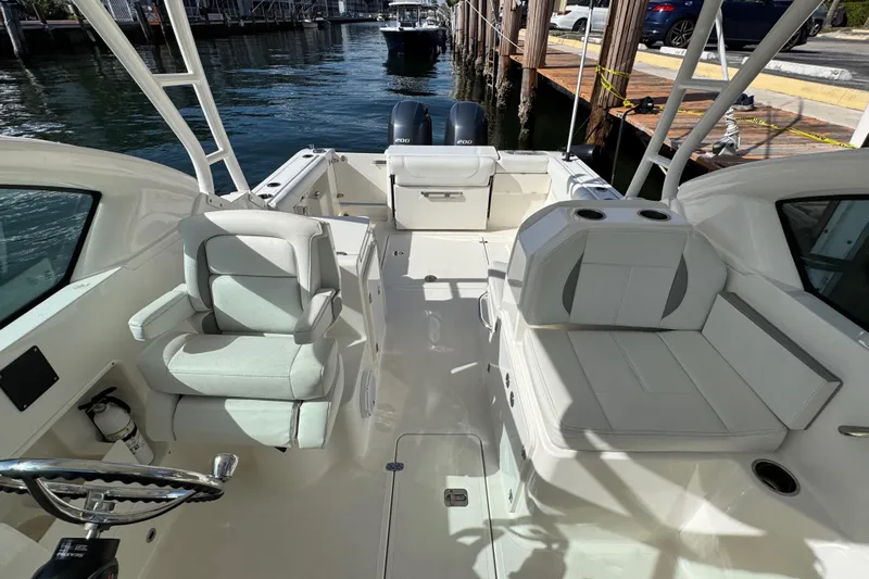  Yacht Photos Pics 2022 Pursuit DC 266 Dual Console boat interior with seating and steering wheel.