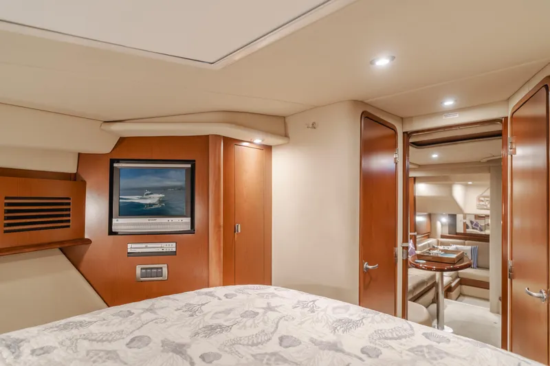 Sea-rinity Yacht Photos Pics Interior cabin of a 2007 Sea Ray 40 Sundancer yacht with wood finishes and cozy bedding.