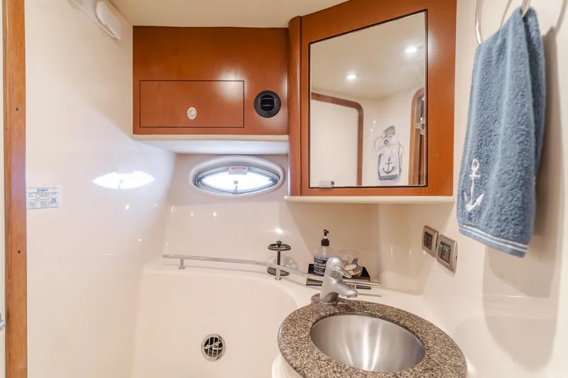 Sea-rinity Yacht Photos Pics 2007 Sea Ray 40 Sundancer bathroom with sink, mirror, and porthole window.