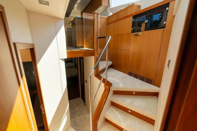 2 Drunk Yacht Photos Pics Interior of 2012 Sunseeker Manhattan 63 yacht, featuring elegant wooden stairs and modern design.