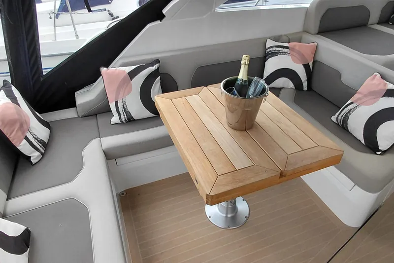 Huge Specifications Yacht Photos Pics Luxurious seating area on 2023 Galeon 405 HTS yacht with wooden table and decorative pillows.