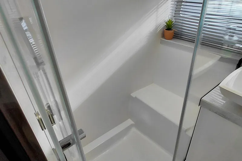 Huge Specifications Yacht Photos Pics Modern shower area in 2023 Galeon 405 HTS yacht with glass door and potted plant.