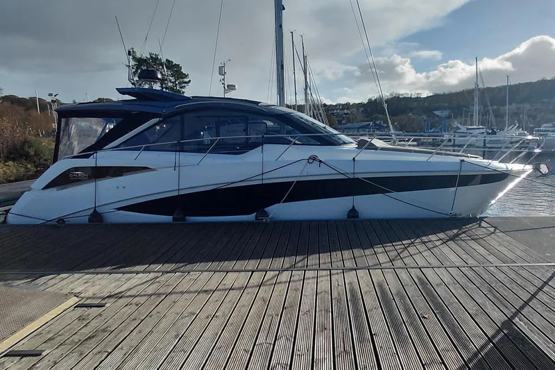 Huge Specifications Yacht Photos Pics 2023 Galeon 405 HTS yacht docked at a marina under a partly cloudy sky.