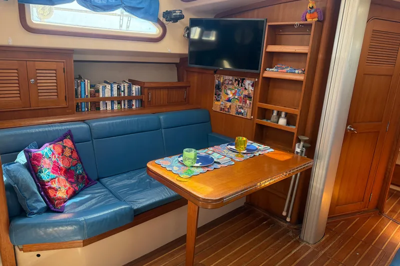 Make Me Laugh Again Yacht Photos Pics Interior of 2005 Island Packet 445 yacht with cozy dining area and blue seating.