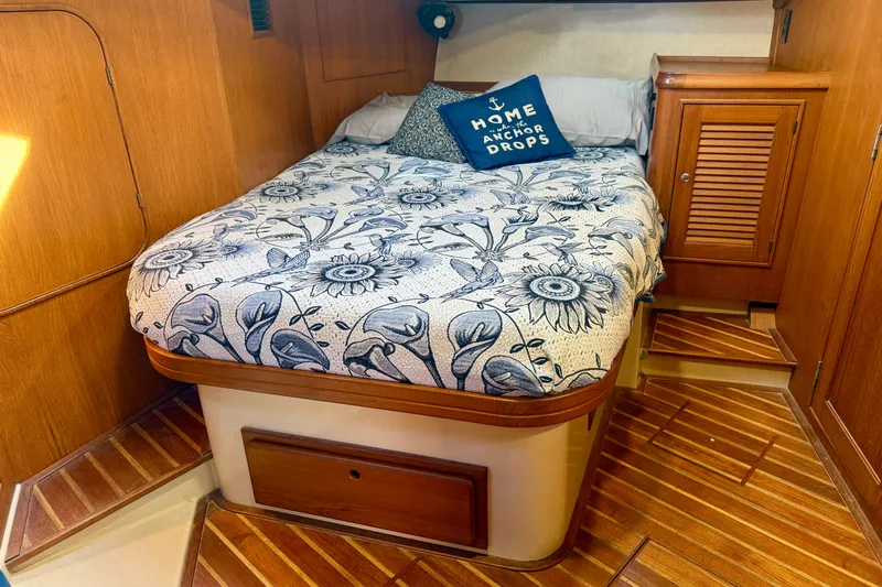 Make Me Laugh Again Yacht Photos Pics Cozy cabin interior of 2005 Island Packet 445 sailboat with floral bedding and wooden accents.