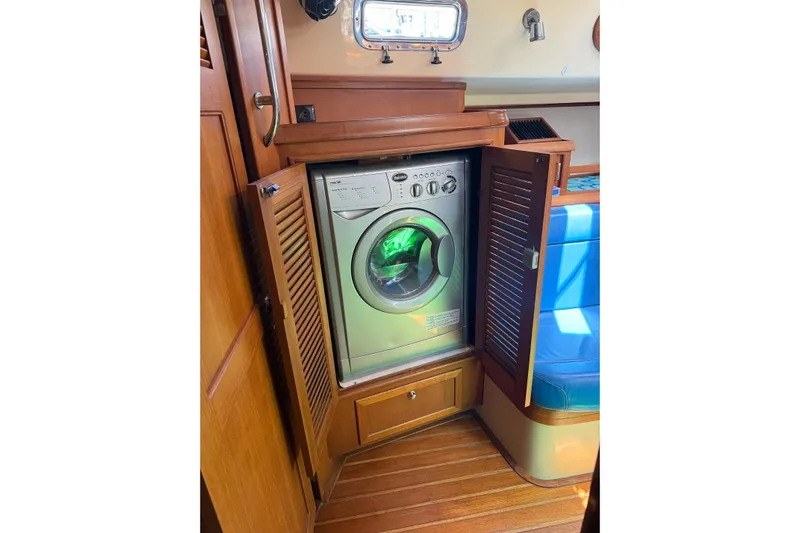 Make Me Laugh Again Yacht Photos Pics Washing machine inside 2005 Island Packet 445 yacht, wooden interior, open cabinet.