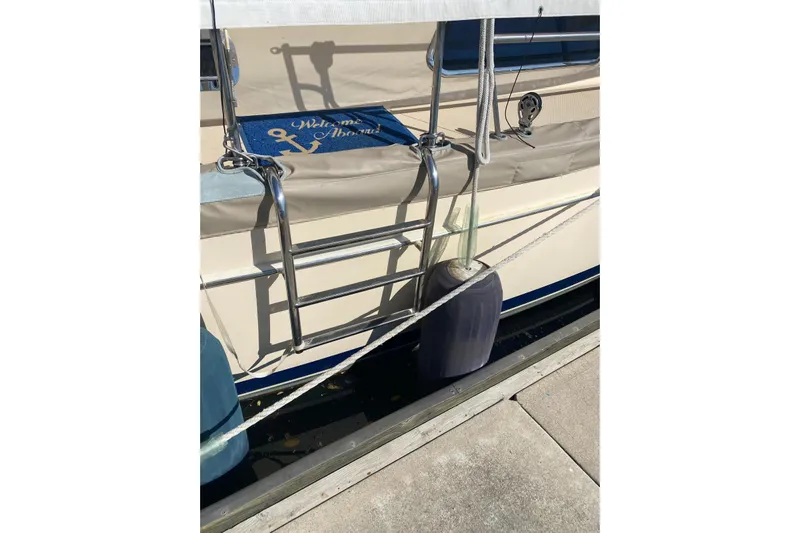 Make Me Laugh Again Yacht Photos Pics Island Packet 445 sailboat with "Welcome Aboard" mat, docked, 2005 model.