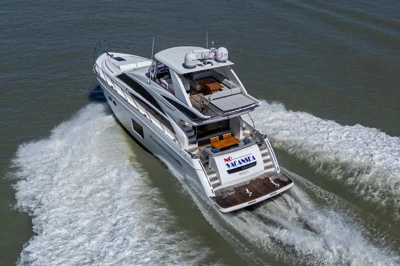 No Vacansea Yacht Photos Pics 2016 Princess Flybridge 64 Motor Yacht cruising on open water, rear view.