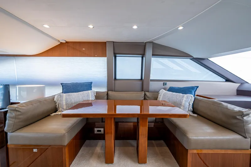 No Vacansea Yacht Photos Pics Interior of 2016 Princess Flybridge 64 Motor Yacht with elegant seating and wooden table.