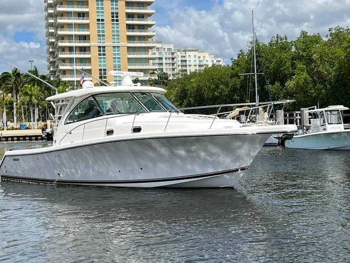 Snot Easy Yacht Photos Pics 2016 Pursuit OS 385 Offshore boat docked near waterfront buildings.