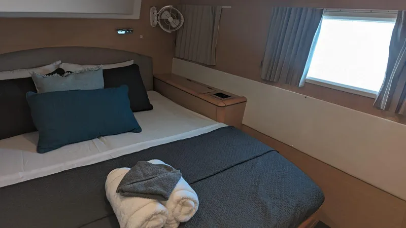 Sandstar Yacht Photos Pics Luxurious cabin interior of 2009 Lagoon 500 yacht with cozy bedding and window view.