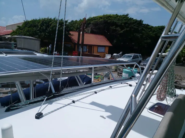 Sandstar Yacht Photos Pics 2009 Lagoon 500 catamaran with solar panels, docked near a coastal building.