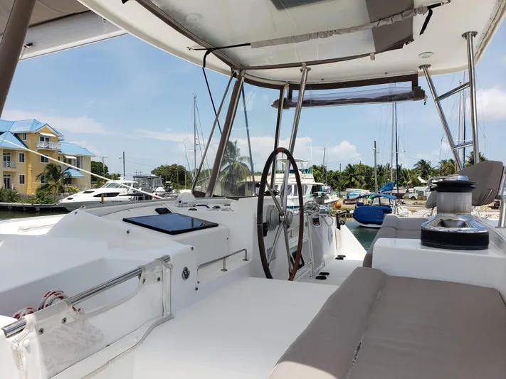 Sandstar Yacht Photos Pics 2009 Lagoon 500 yacht cockpit with steering wheel, marina view, and clear sky.