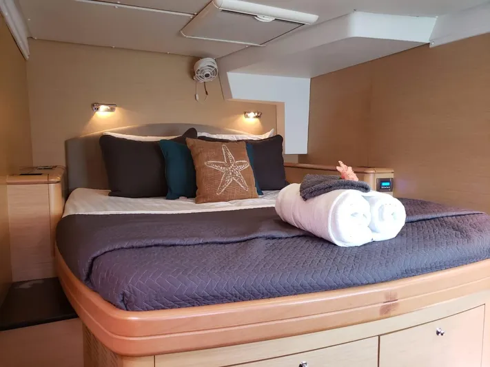 Sandstar Yacht Photos Pics Luxurious cabin interior of 2009 Lagoon 500 yacht with cozy bedding and ambient lighting.