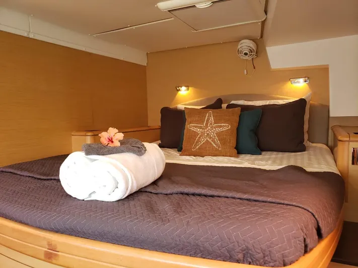 Sandstar Yacht Photos Pics Luxurious cabin interior of 2009 Lagoon 500 yacht with cozy bedding and decorative pillows.