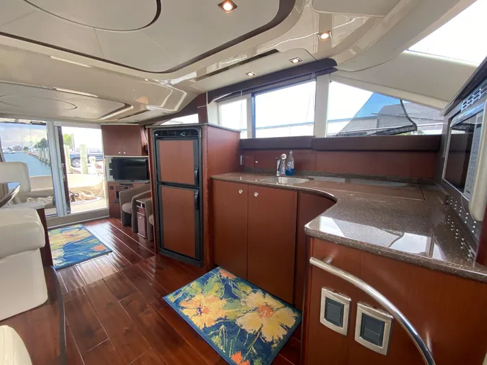 Lucid Dreams Yacht Photos Pics Luxurious interior of 2014 Meridian 441 Sedan yacht with modern kitchen and seating area.