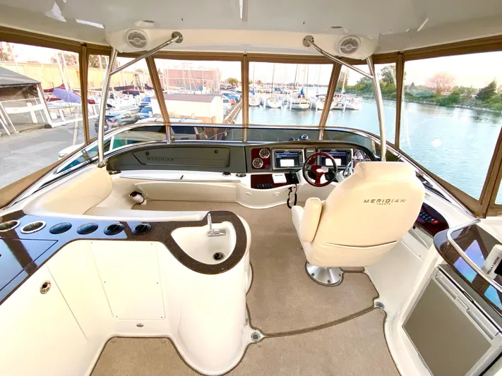 Lucid Dreams Yacht Photos Pics 2014 Meridian 441 Sedan yacht cockpit with modern controls and panoramic marina view.