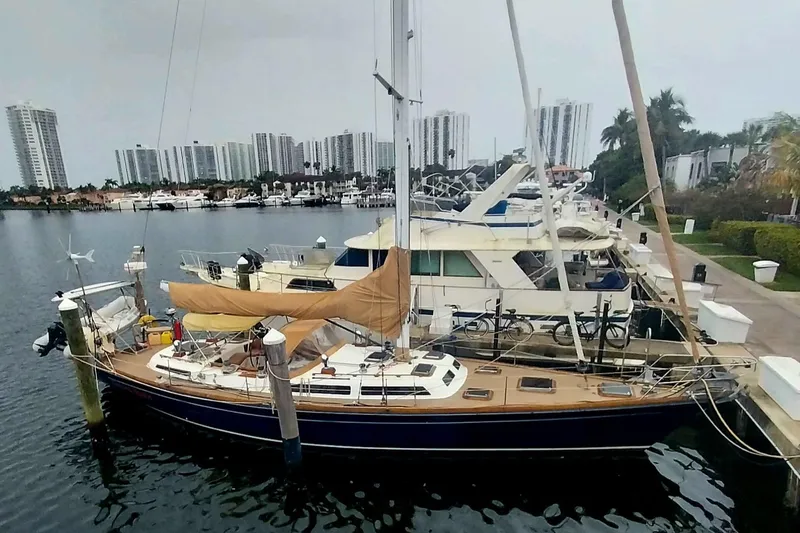 Sacred Space Yacht Photos Pics Sailboat docked in marina, Hans Christian Christina 1992, with city skyline in background.