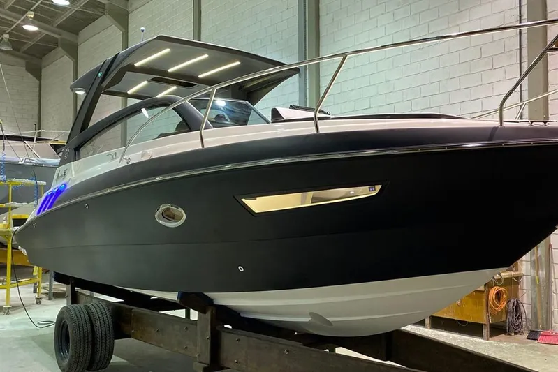  Yacht Photos Pics 2025 Hanover 305 boat in a showroom, featuring sleek black and white design.