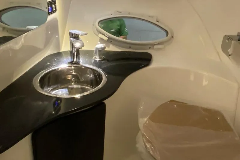  Yacht Photos Pics Modern bathroom interior in 2025 Hanover 305, featuring sleek sink and porthole window.