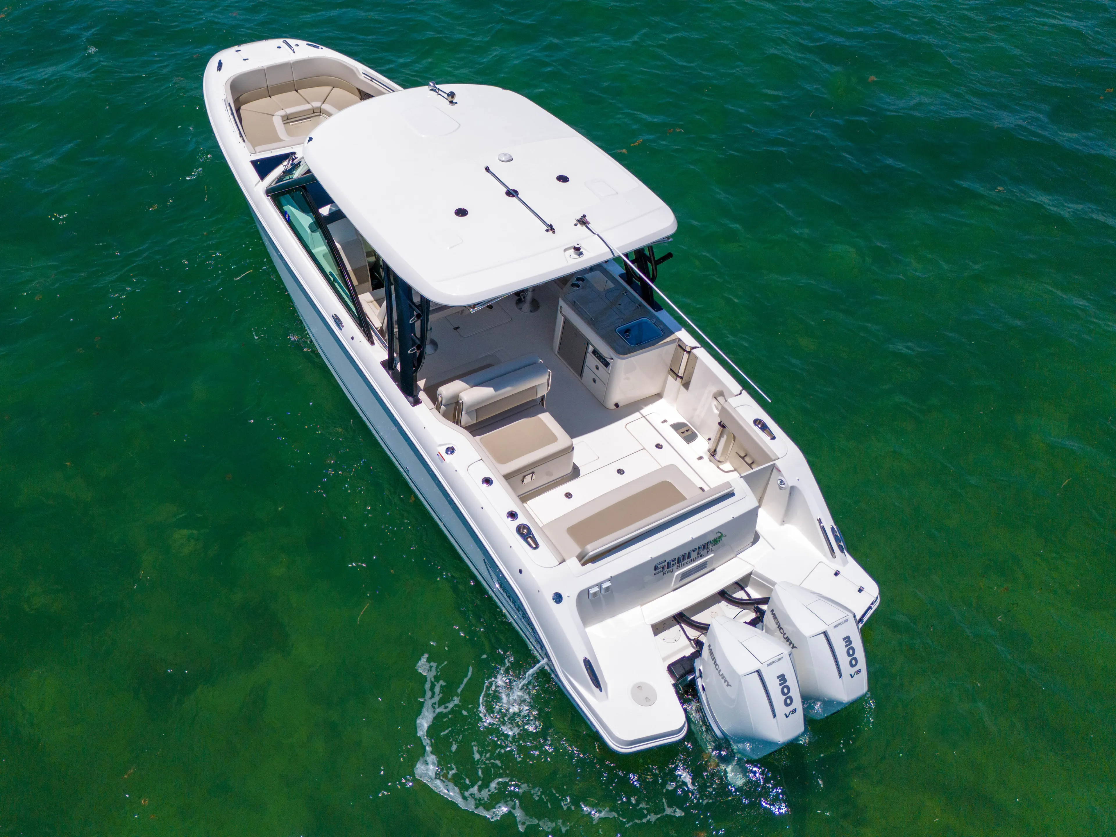  Yacht Photos Pics 2024 Boston Whaler 325 Vantage boat cruising on clear green water.