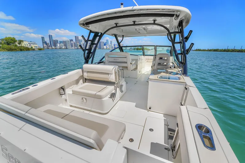  Yacht Photos Pics 2024 Boston Whaler 325 Vantage boat on water, city skyline in background.