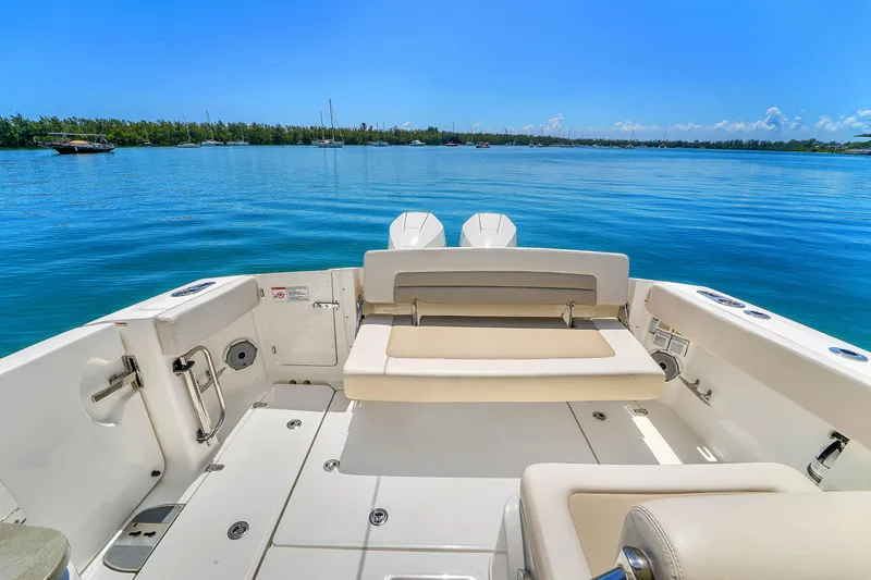  Yacht Photos Pics 2024 Boston Whaler 325 Vantage boat interior with seating, overlooking calm blue waters.