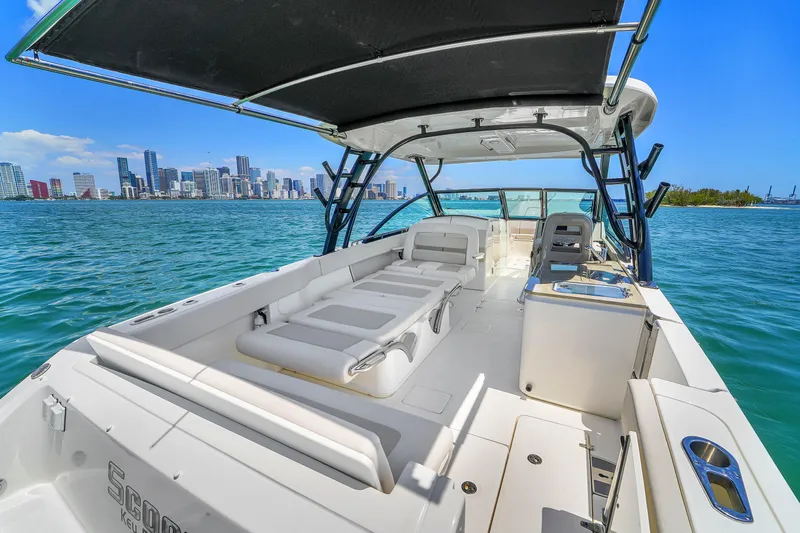  Yacht Photos Pics 2024 Boston Whaler 325 Vantage boat with spacious deck, city skyline in background.
