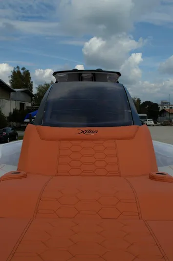  Yacht Photos Pics Futuristic DNA 46 model boat with orange seating, 2025 design, under a cloudy sky.