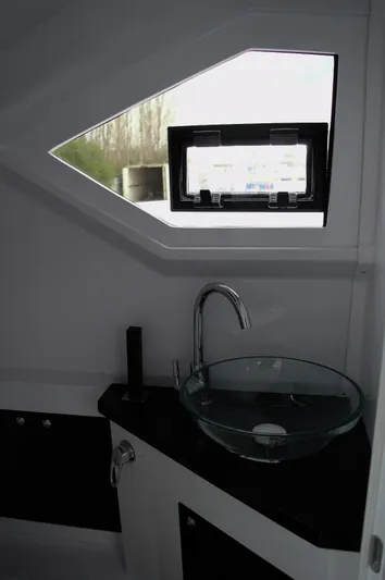  Yacht Photos Pics Modern bathroom interior in DNA 46, 2025 model, featuring glass sink and geometric window.