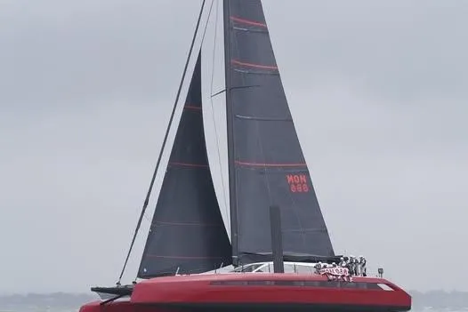 Highland Fling 18 Yacht Photos Pics 2023 Gunboat 80 sailing yacht with sleek black sails on a cloudy day.