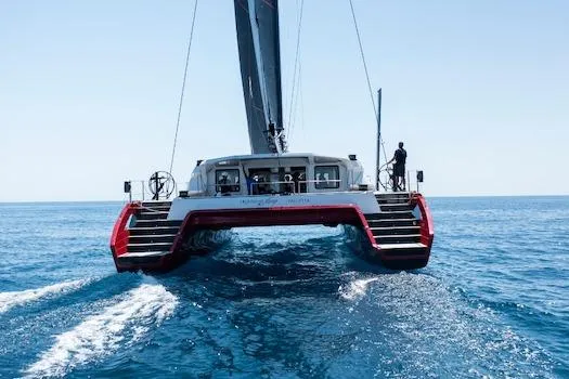 Highland Fling 18 Yacht Photos Pics 2023 Gunboat 80 catamaran sailing on open sea, rear view.