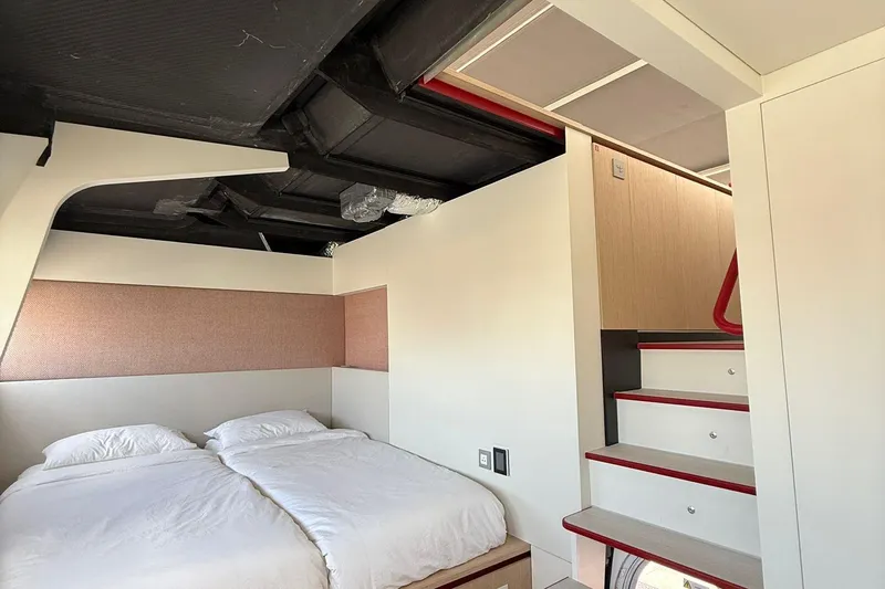 Highland Fling 18 Yacht Photos Pics Modern interior of 2023 Gunboat 80 yacht with cozy bedroom and sleek staircase design.