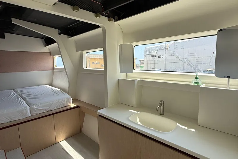 Highland Fling 18 Yacht Photos Pics Modern interior of 2023 Gunboat 80 yacht with bed and sink, featuring large windows.